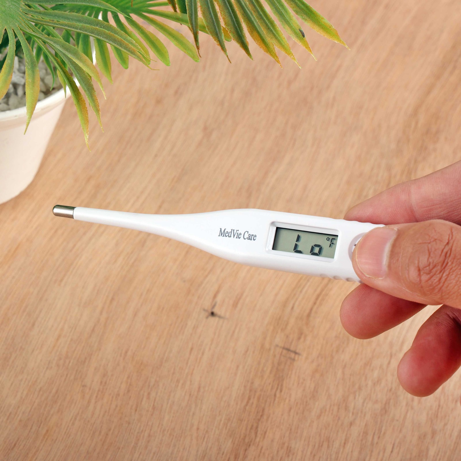MedVie Care digital thermometer held in hand showing the reading